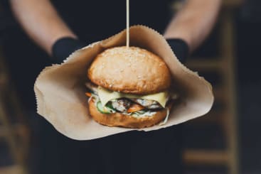 A burger at a street food festival in brown paper