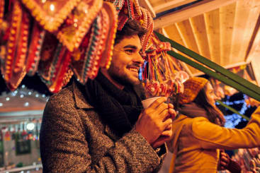 male enjoying drink at Christmas market
