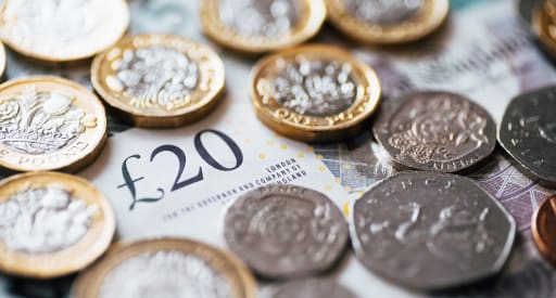 a twenty pound note with coins