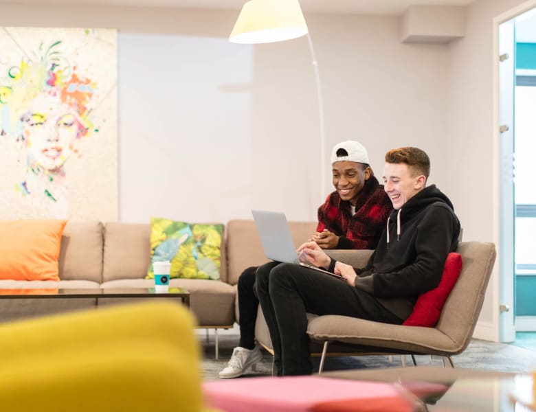 Students in the communal lounge browsing on a laptop together
